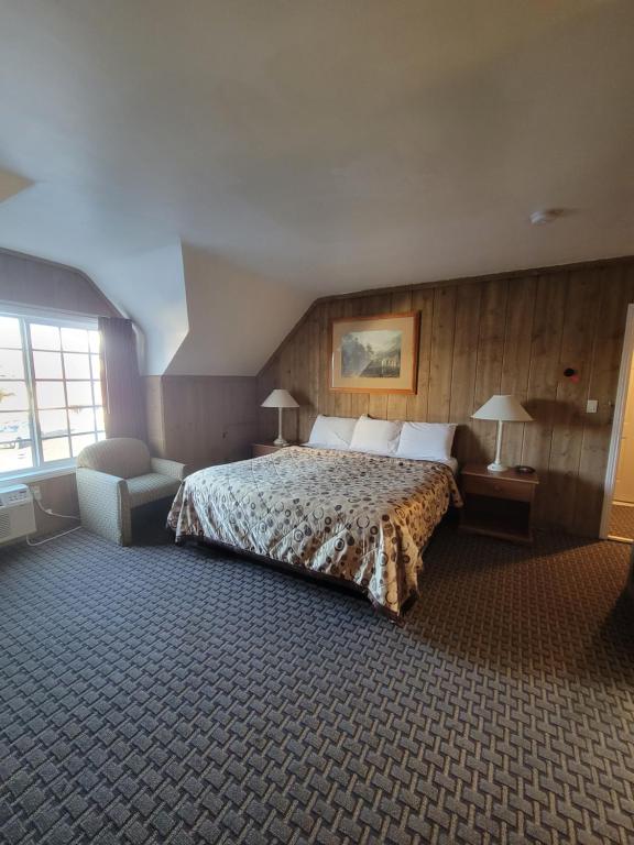 a hotel room with a bed and a chair at Townhouse Motel in Bishop