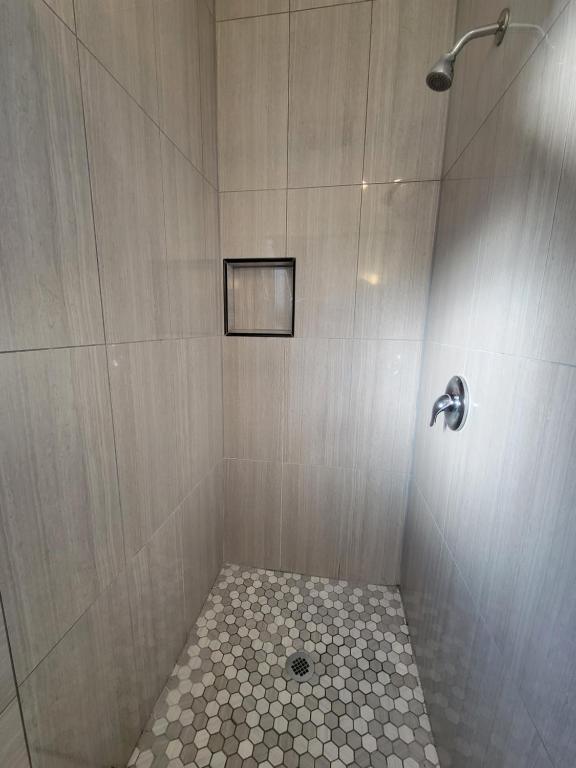 a bathroom with a shower with a tiled floor at Townhouse Motel in Bishop