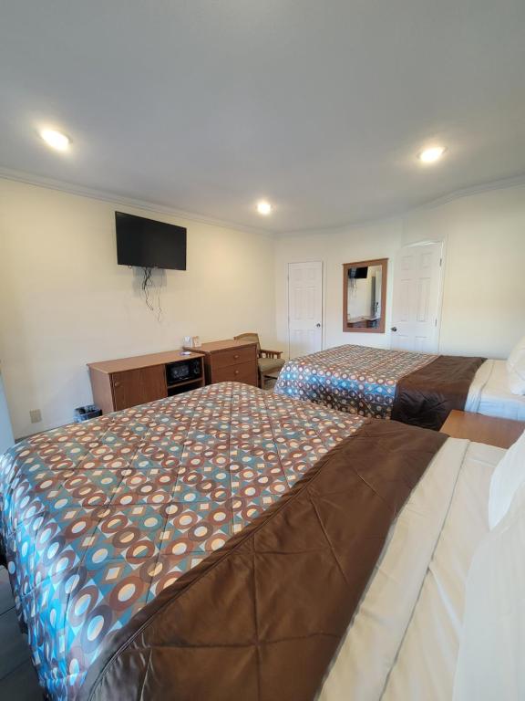 a bedroom with two beds and a flat screen tv at Townhouse Motel in Bishop