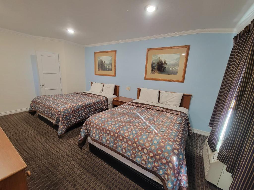 a hotel room with two beds and a television at Townhouse Motel in Bishop