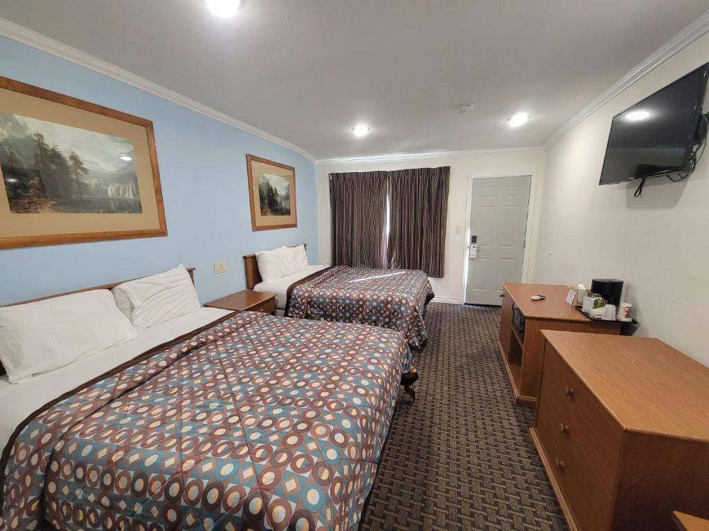 a hotel room with two beds and a television at Townhouse Motel in Bishop