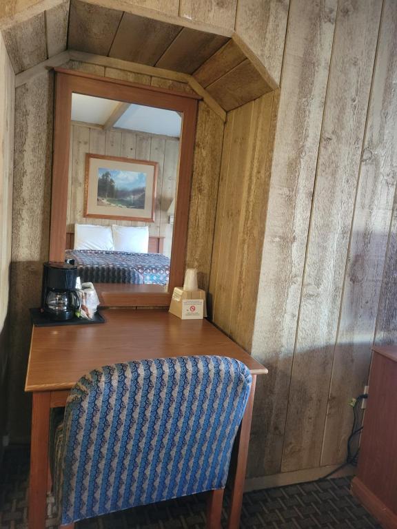 a room with a table and a mirror and a bed at Townhouse Motel in Bishop