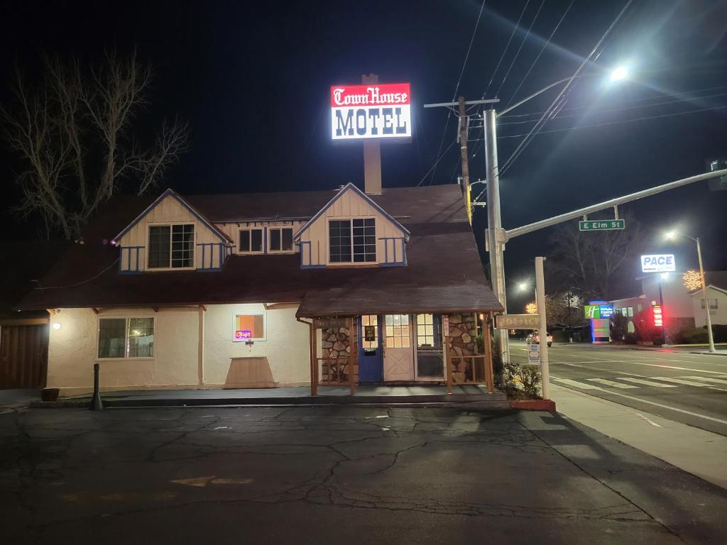 a house with a neon sign on top of it at Townhouse Motel in Bishop