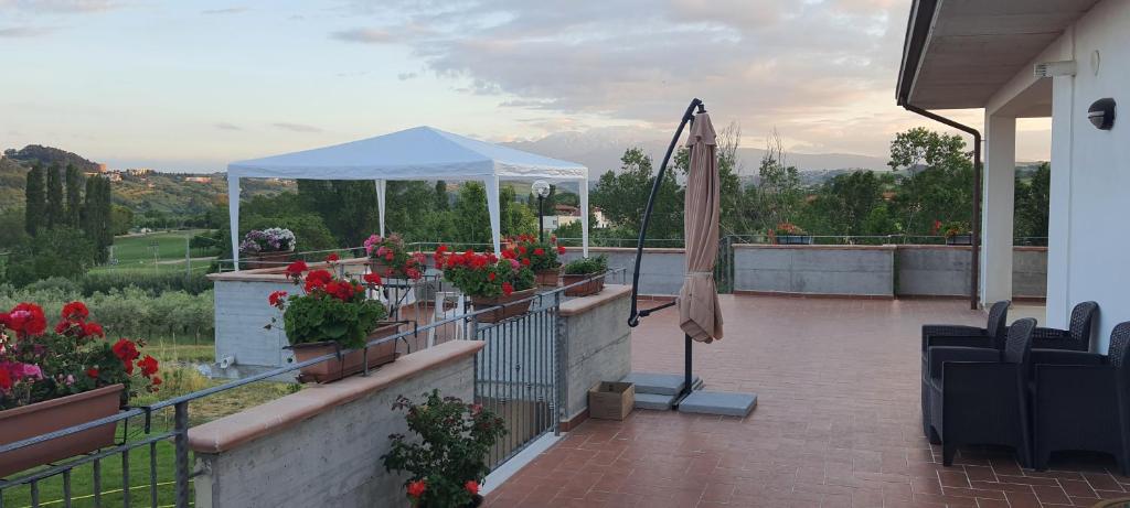 eine Terrasse mit einem Zelt und Blumen auf dem Balkon in der Unterkunft Casa Vacanze Cerreto 2 in Miglianico