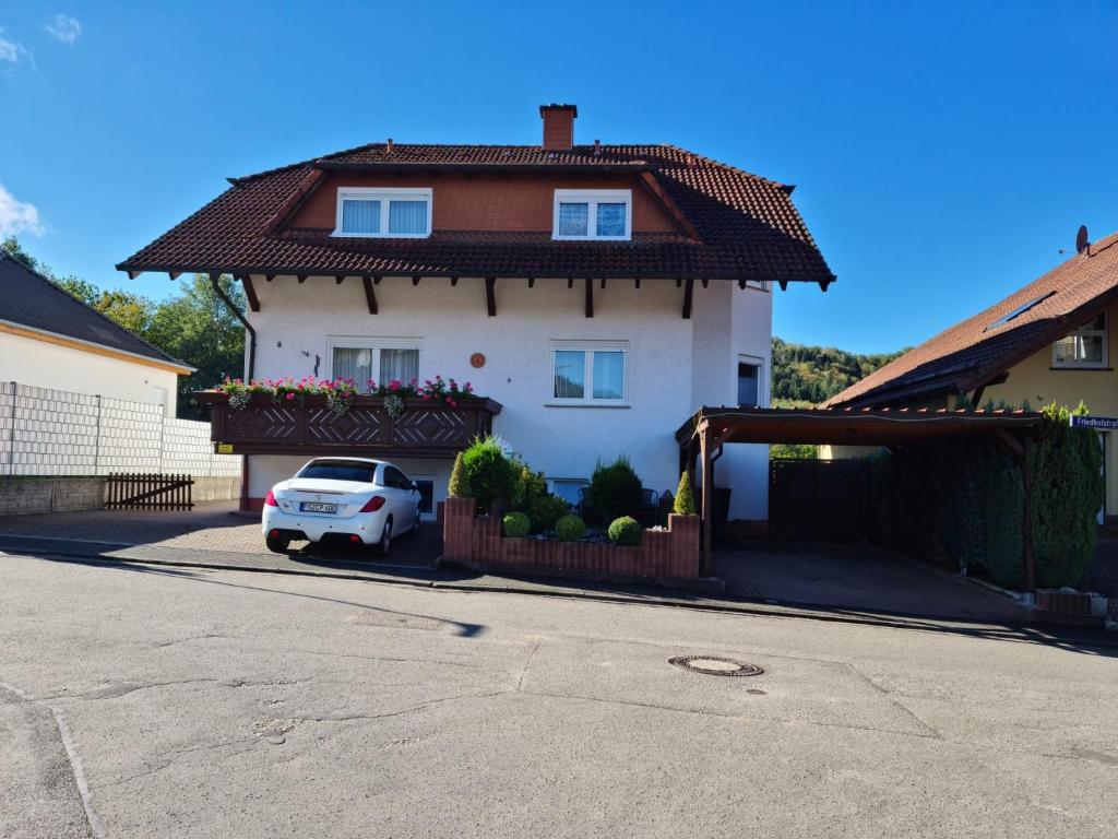 a white car parked in front of a house at Ferienwohnung Cornelia und Michael Persang GbR in Eppenbrunn