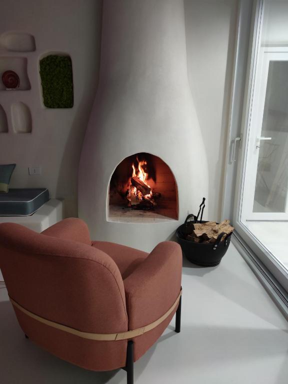 a living room with a chair and a fire place at Casa Mediterranea Jacuzzi riscaldata con Caminetto in Specchiolla