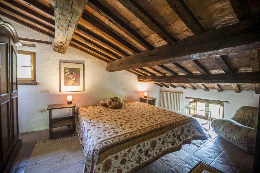 um quarto com uma cama num quarto com tectos em madeira em La Fonte, Umbria em Lugnano