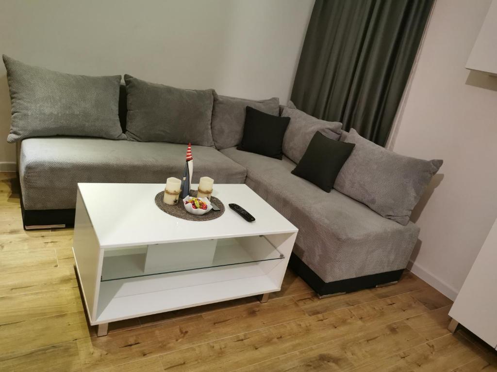 a living room with a couch and a table with a candle at Apartman Hill in Mirijevo