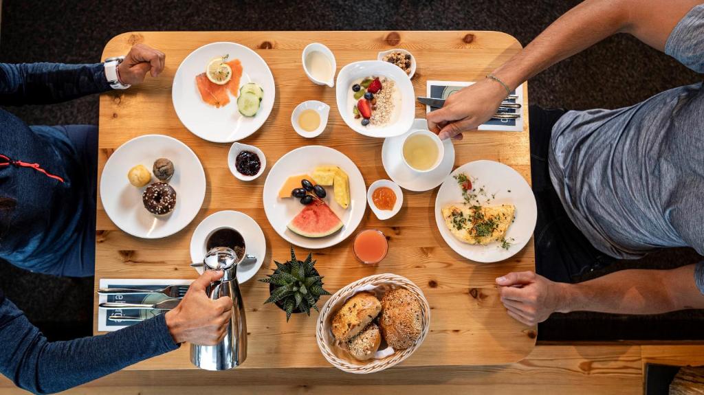 un gruppo di persone seduti a un tavolo con cibo di die berge lifestyle-hotel sölden a Sölden