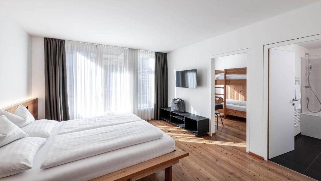a bedroom with a large bed and a mirror at die berge lifestyle-hotel Sölden in Sölden