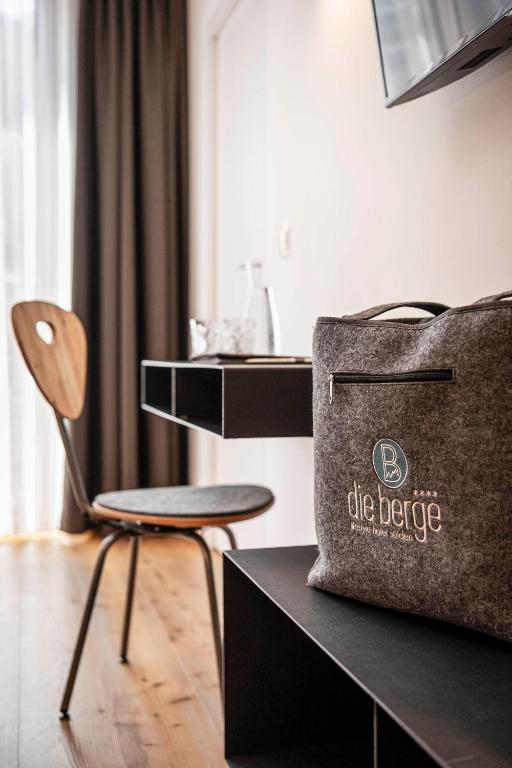 a bag and a chair in a room at die berge lifestyle-hotel Sölden in Sölden