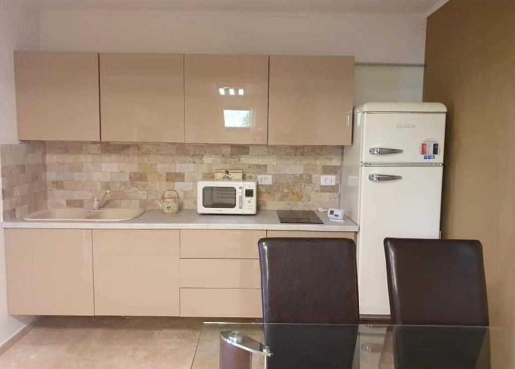 a kitchen with a table and two chairs and a refrigerator at Apartament Nicolle in Poiana Brasov