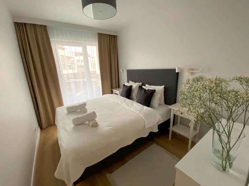 a bedroom with a large white bed with a window at Urokliwy apartament HAVEN nad morzem+free parking in Kołobrzeg
