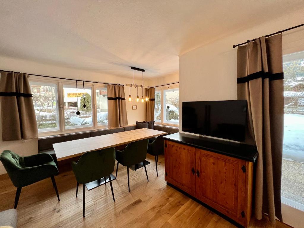 a dining room with a table and a flat screen tv at Haus Stille Nacht Wagrain in Wagrain