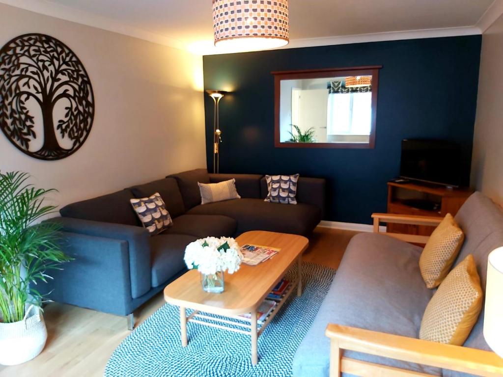 a living room with a couch and a table at 1 WATER PUMP HOUSE in Bury Saint Edmunds