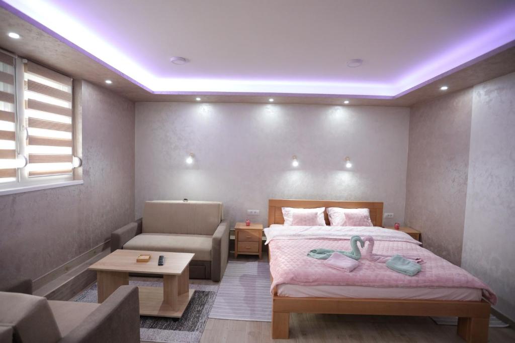 um quarto com uma cama e um sofá e uma cama e um sofá em Apartmani Božović em Nova Varos