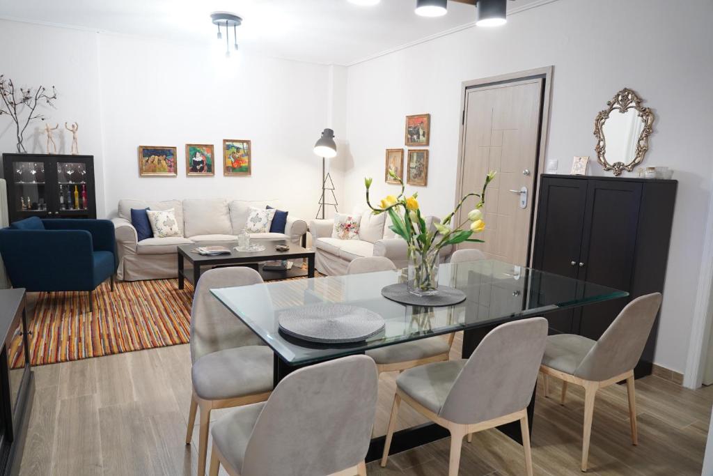 sala de estar con mesa de cristal y sillas en Larissa Downtown Apartment With Parking en Larisa
