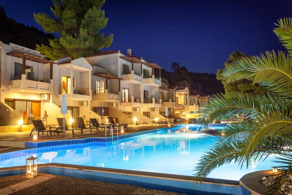 a villa with a swimming pool at night at Blue Green Bay in Panormos Skopelos