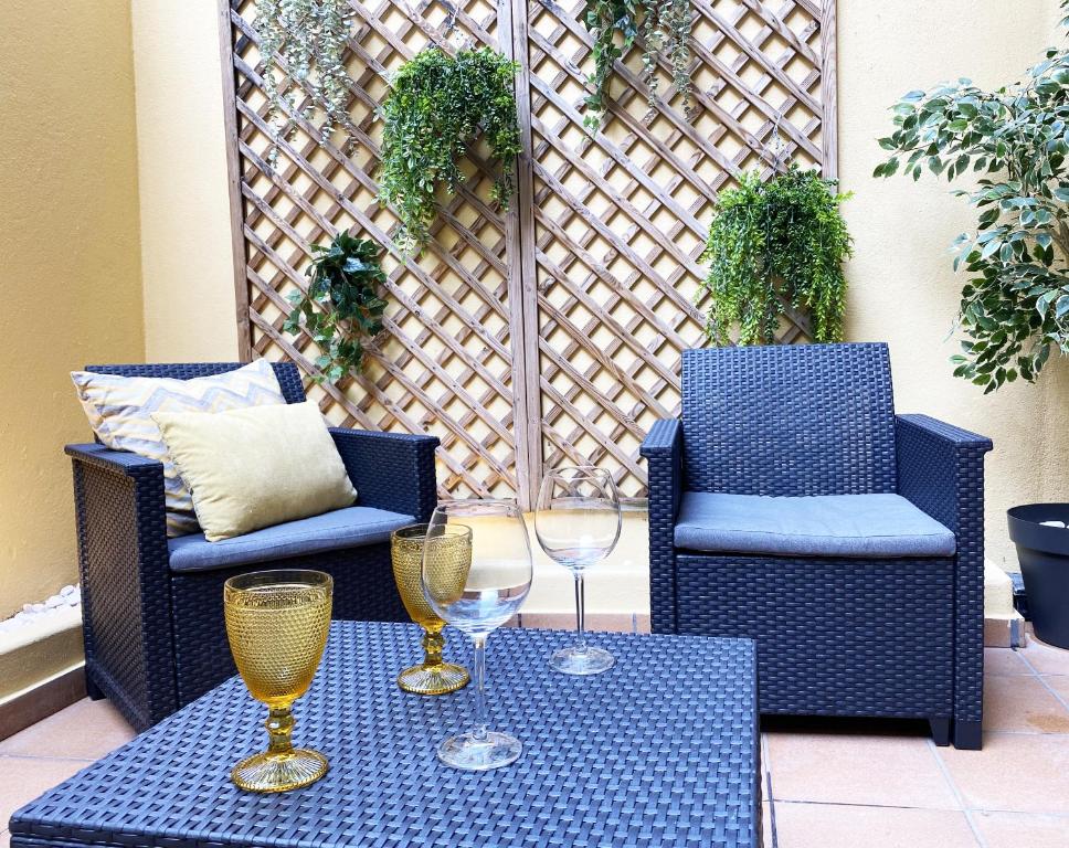 Duas cadeiras e uma mesa com copos de vinho num pátio em El Patio 79 em Lisboa
