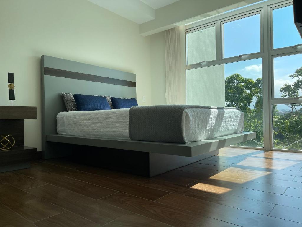una camera da letto con un grande letto con cuscini blu di Lovely Apartment near Costa Rica airport a Heredia