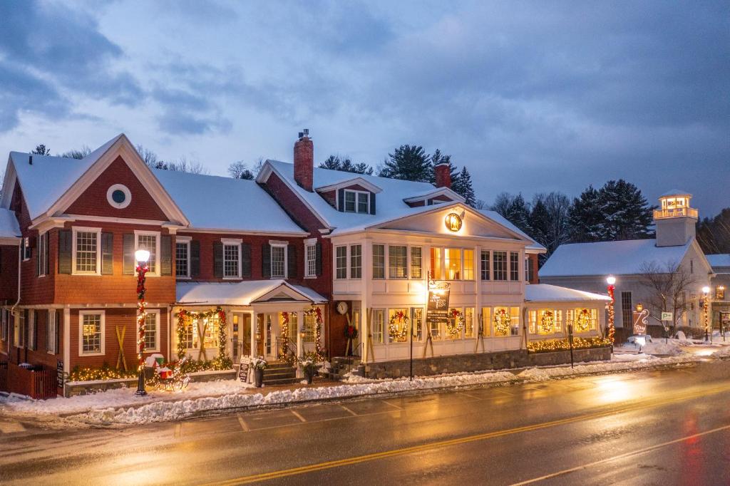 una grande casa con luci natalizie su una strada di Green Mountain Inn a Stowe