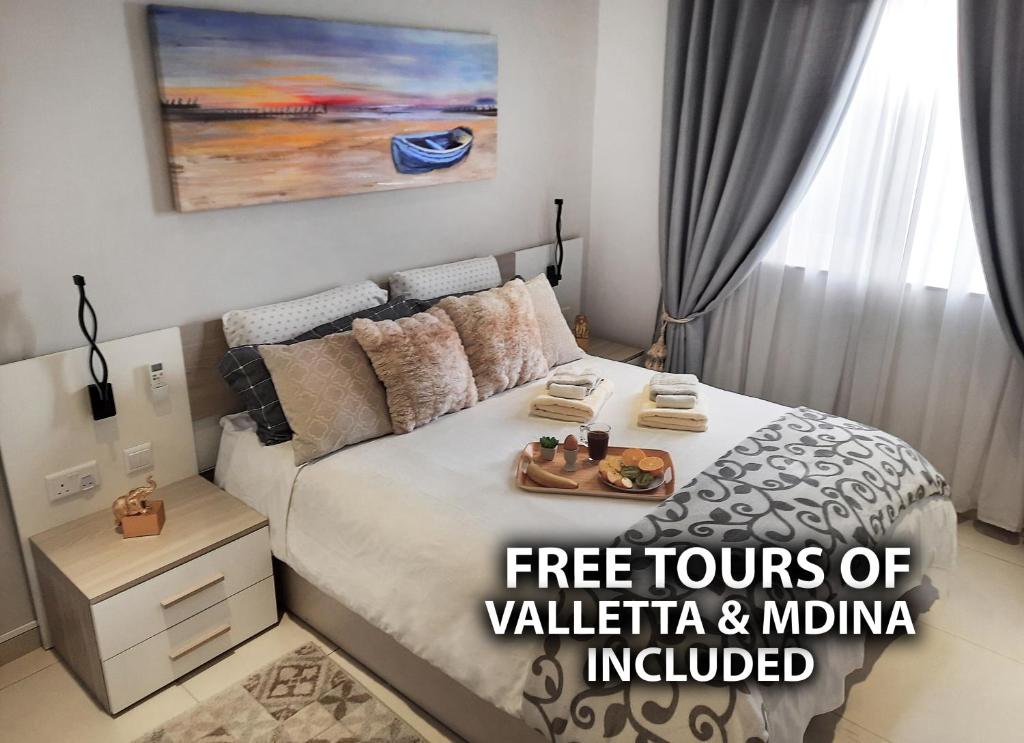 ein Schlafzimmer mit einem Bett und einem Tablett mit Essen drauf in der Unterkunft Cozy Rooms - Great Bus Connections - Free Parking in Mosta