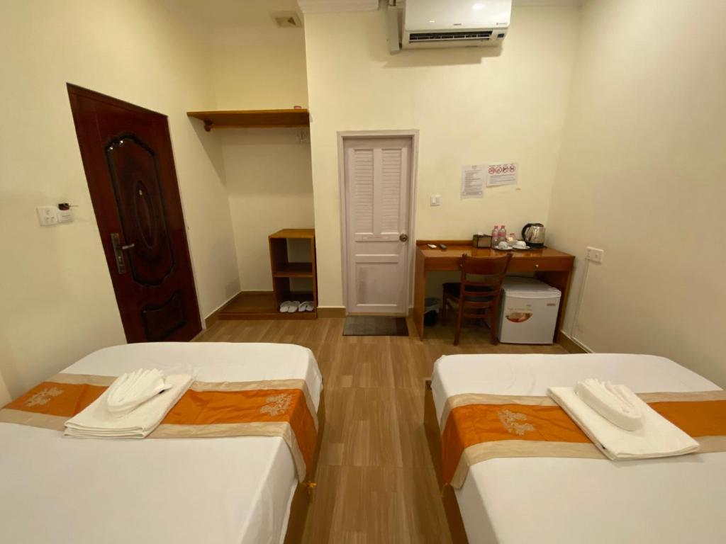 Postel nebo postele na pokoji v ubytování Phnom Penh Le Vincent Hotel