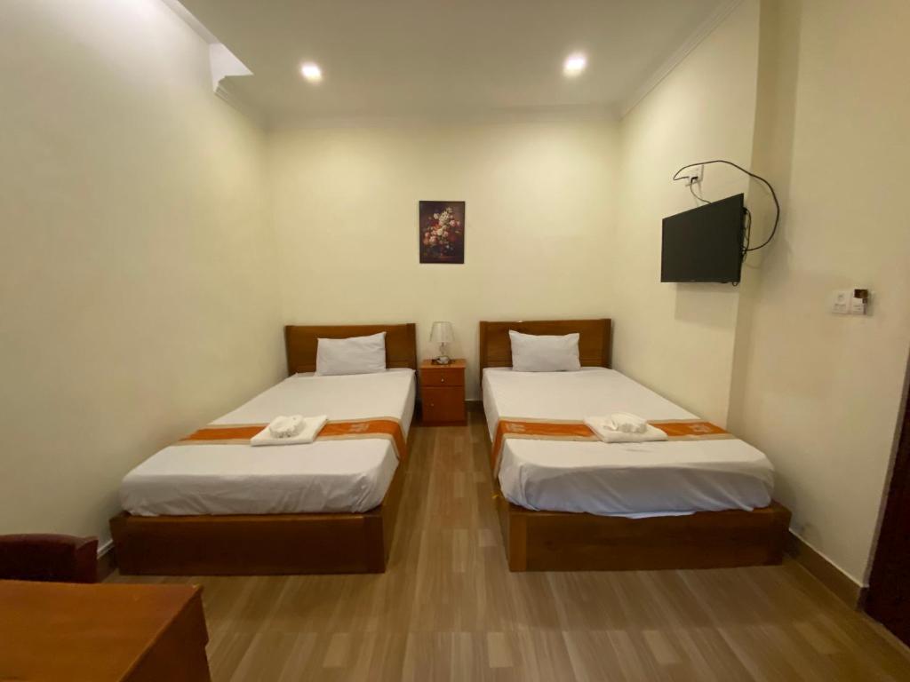Postel nebo postele na pokoji v ubytování Phnom Penh Le Vincent Hotel