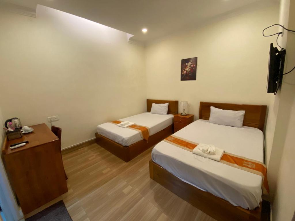 Postel nebo postele na pokoji v ubytování Phnom Penh Le Vincent Hotel