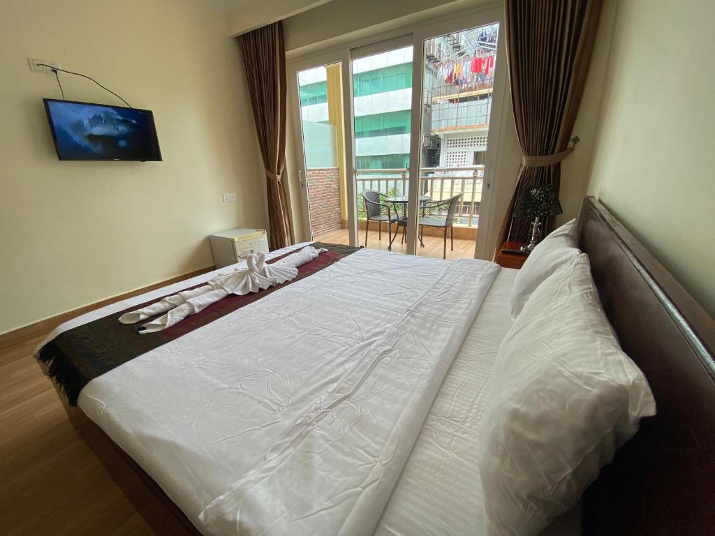 Postel nebo postele na pokoji v ubytování Phnom Penh Le Vincent Hotel
