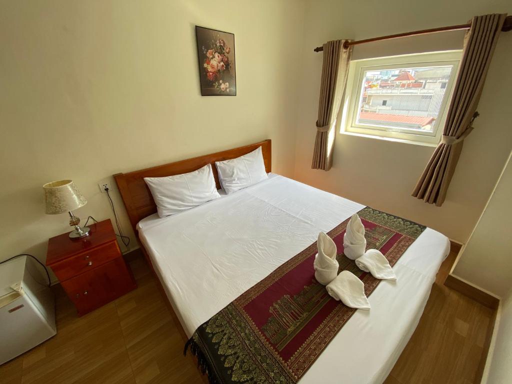 Postel nebo postele na pokoji v ubytování Phnom Penh Le Vincent Hotel