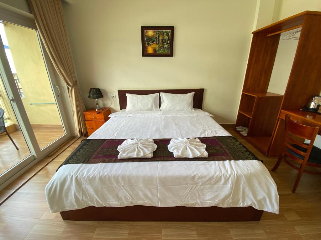 Postel nebo postele na pokoji v ubytování Phnom Penh Le Vincent Hotel