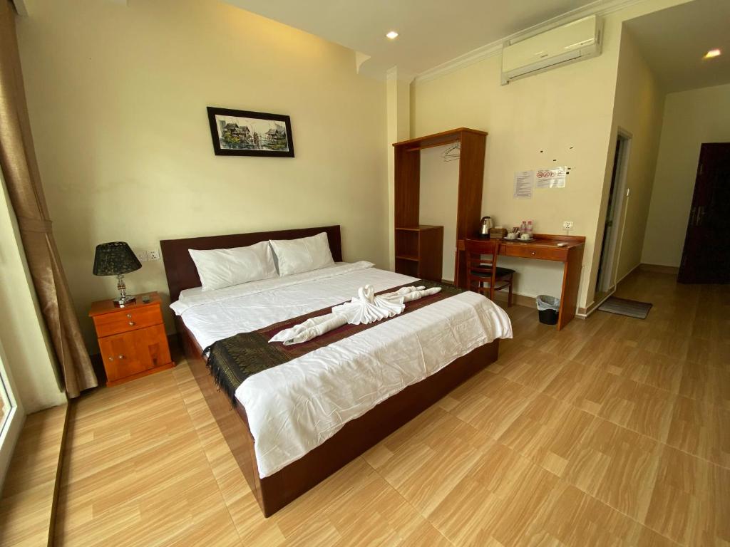 Postel nebo postele na pokoji v ubytování Phnom Penh Le Vincent Hotel