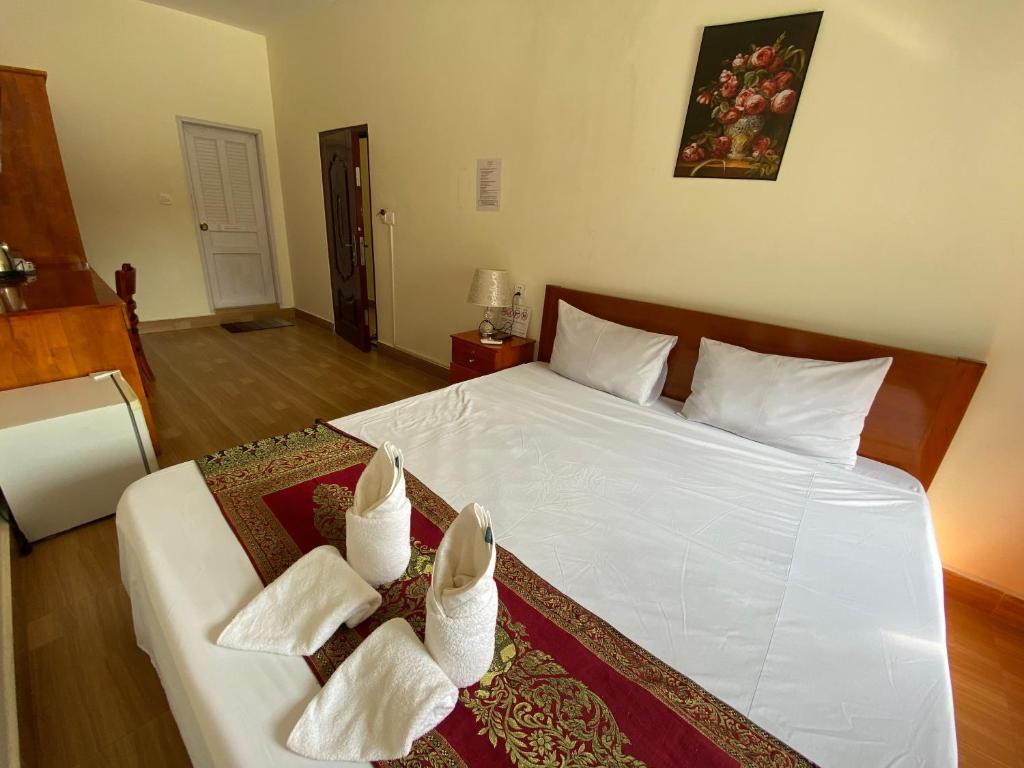 Postel nebo postele na pokoji v ubytování Phnom Penh Le Vincent Hotel
