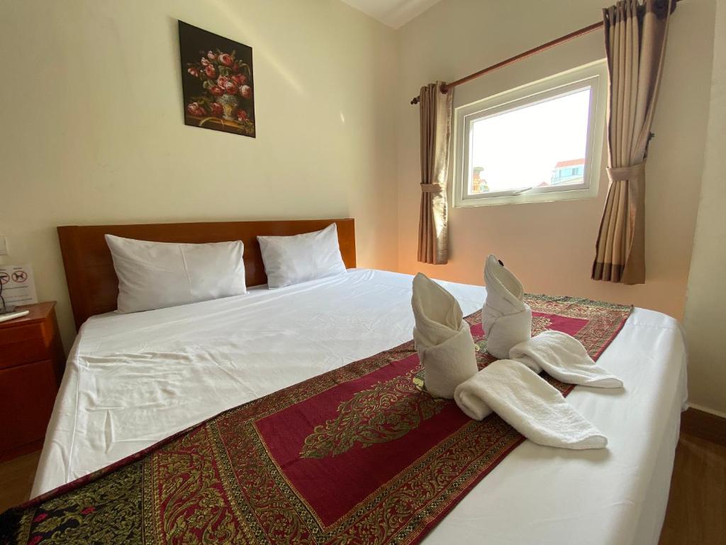 Postel nebo postele na pokoji v ubytování Phnom Penh Le Vincent Hotel