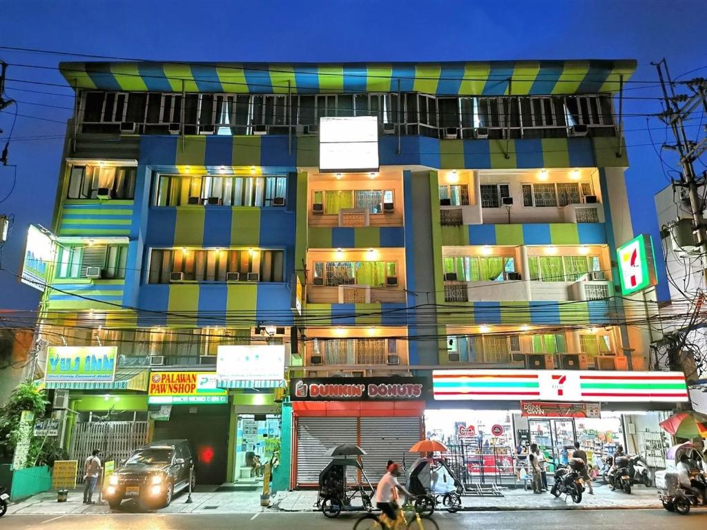 マニラにあるYuj Inn Pasayの人と車が通る道の建物