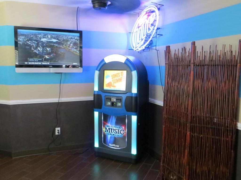 a video game machine in a room with a tv at Oasis Boutique Motel in Boulder City
