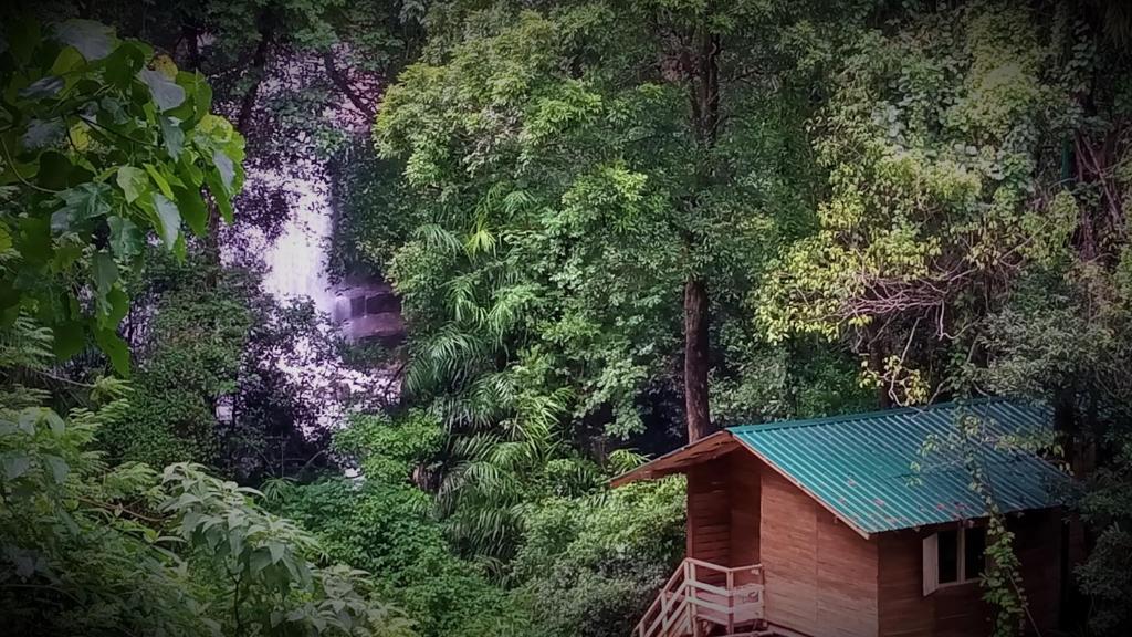 a small house in front of a waterfall at Trekkers' Hut Knuckles in Kaduwela