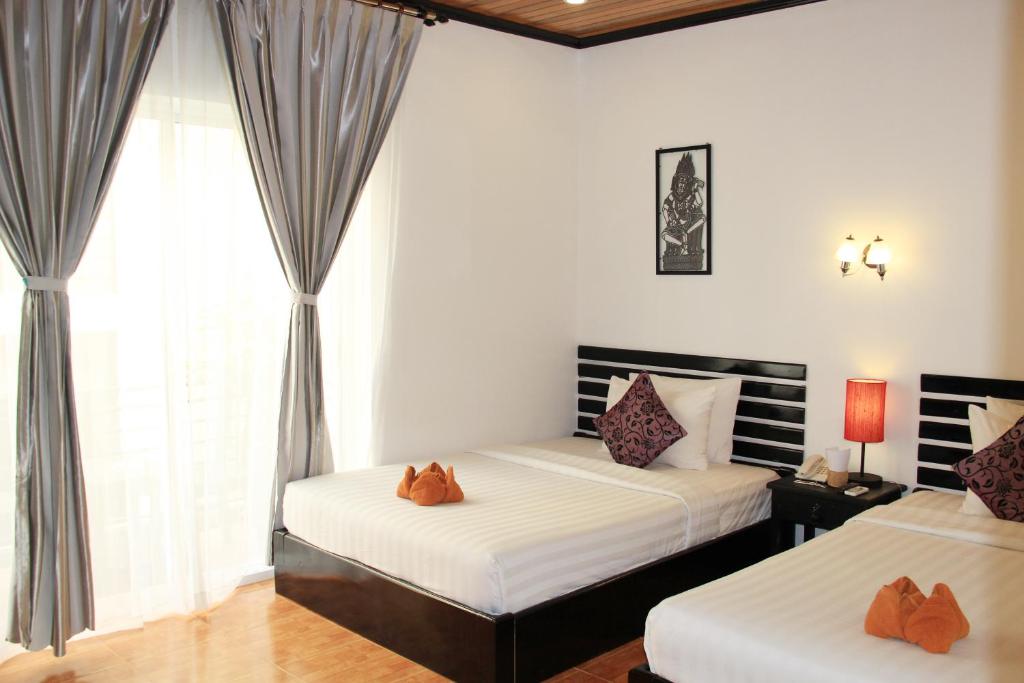 Postel nebo postele na pokoji v ubytování Golden Orchid Angkor