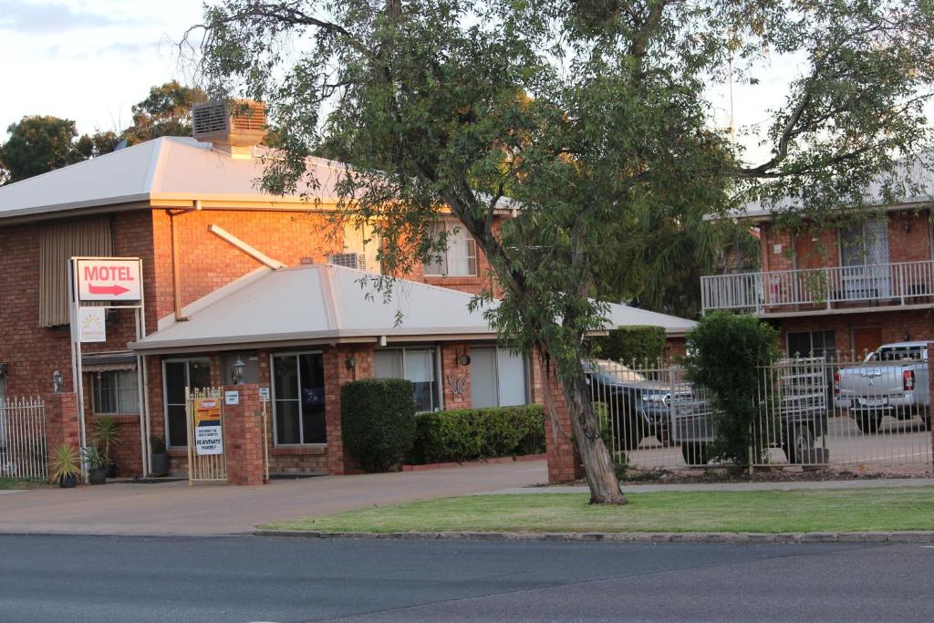 a building with a tree in front of it at Red Cliffs Colonial Motor Lodge, Mildura Region in Red Cliffs