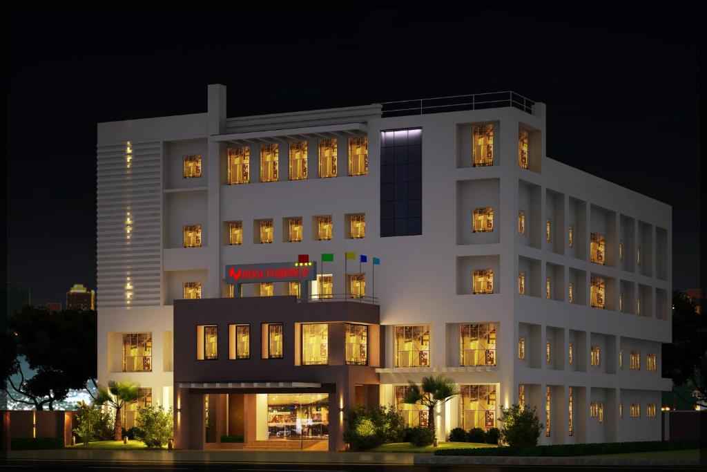 a large white building with many windows at night at Hotel Niya Regency in Trichūr