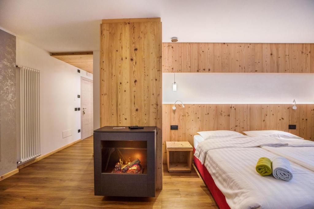 - une chambre avec une cheminée à côté d'un lit dans l'établissement Chalet Osmar Suite 1, à Campitello di Fassa