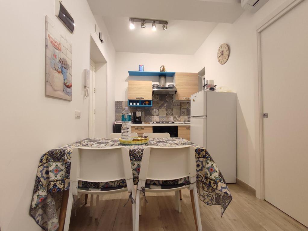 La cuisine est équipée d'une table, de chaises et d'un réfrigérateur. dans l'établissement Masa House, à Palerme