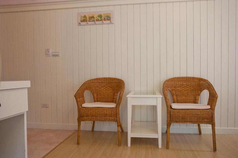 two wicker chairs and a table in a room at Bear Meets Moose Homestay B&amp;B in Puli