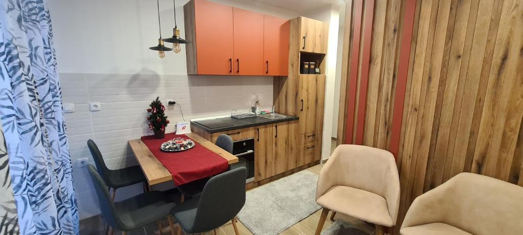 una cucina e una sala da pranzo con tavolo e sedie di Apartman Mina Jezero a Divčibare