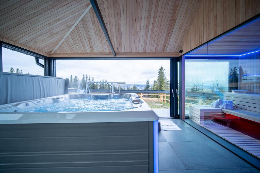 a large bathroom with a tub with a large window at Royal Apartments & Spa Zakopane-Cyrhla in Zakopane