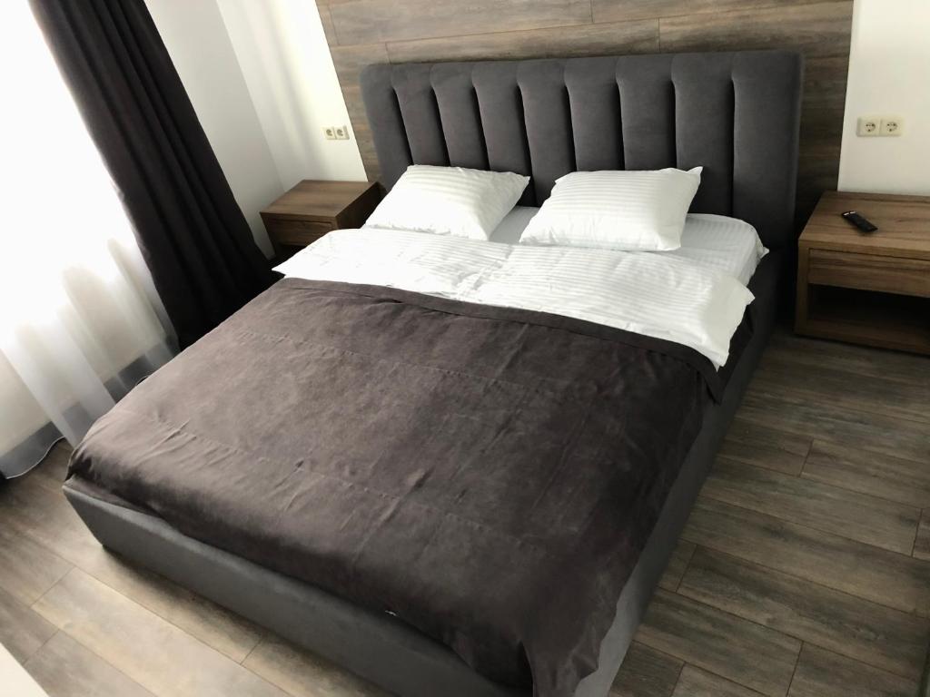 a bedroom with a large bed with a black headboard at ApartHotel in Mukacheve