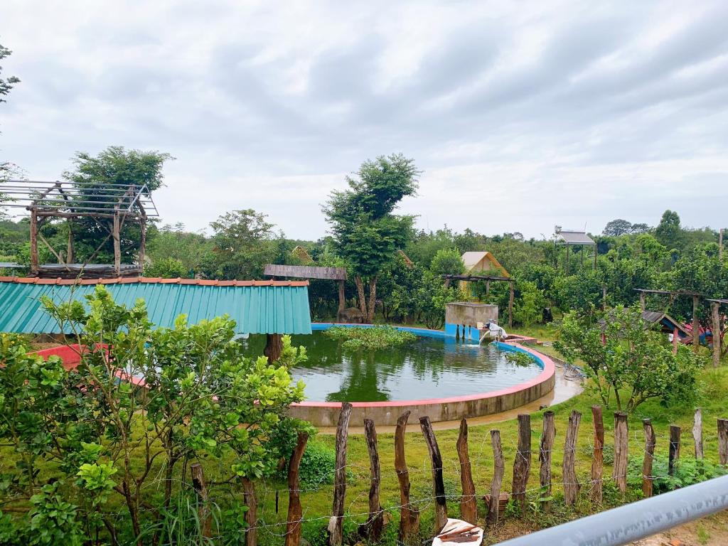 a playground with a pond in a park at Rice straw Green lodge- resort in Quan Tom