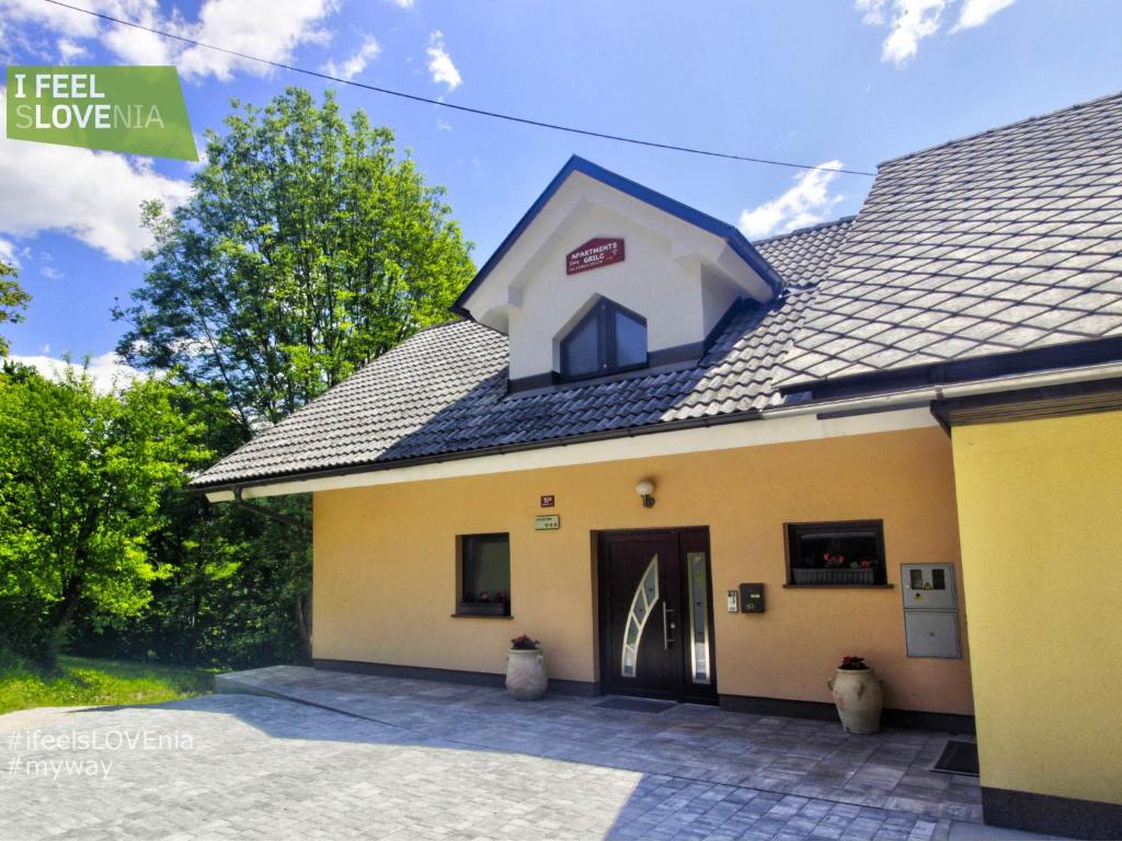 un edificio blanco y amarillo con garaje en Apartmaji Grilc en Bled