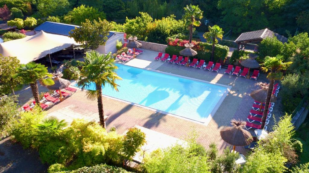 - une vue sur la piscine bordée de palmiers dans l'établissement Hameau du Prat, à Ribes